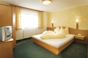 a hotel room with a bed and a television at Apart Franz Josef in Stumm