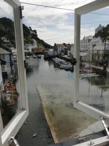 a flooded street with lots of water and buildings at The House on the Props in Polperro