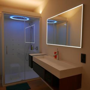a bathroom with a sink and a shower with a mirror at Margaretha's Room in Mechelen