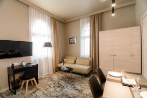 - un salon avec un canapé et une table dans l'établissement Boutique Apart Hotel Adagio, à Tbilissi