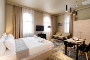 une chambre d'hôtel avec un lit et un salon dans l'établissement Boutique Apart Hotel Adagio, à Tbilissi