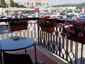 a balcony with flowers and tables and a parking lot at B&B Monté in Montesilvano