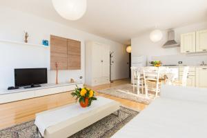a living room with a white couch and a kitchen at Apartments DDD in Baška