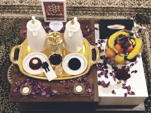 una mesa con una bandeja con un set de té y flores en Qasr Rayana Aparthotel, en Buraidah
