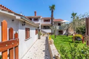 a house with a pathway leading to a yard at Apartments Rita in Poreč