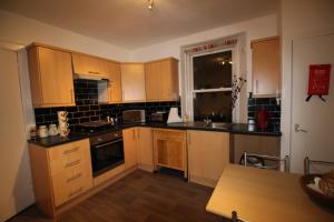 een kleine keuken met houten kasten en een tafel bij 63 Argyle Street in Inverness