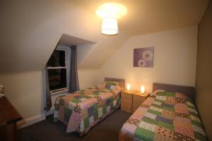 een hotelkamer met twee bedden en een raam bij 63 Argyle Street in Inverness