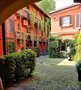 een oranje gebouw met planten erop bij Alzaia Naviglio Grande in Milaan