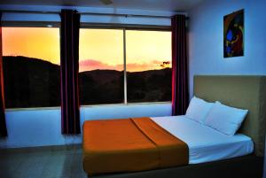 a bedroom with a bed in front of a window at Vagamon Clouds in Vagamon