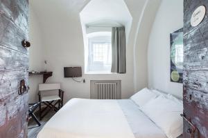 1 dormitorio con cama blanca y ventana en Lacasadiscorta, en Almè