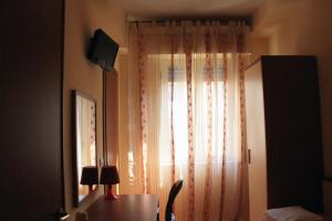 雷焦卡拉布里亞的住宿－Bed And Coffee，客房设有带书桌的窗户和带台灯的桌子。
