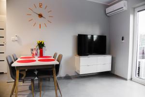 ein Esszimmer mit einem Tisch und einer Uhr an der Wand in der Unterkunft ULMA apartment in Wieliczka