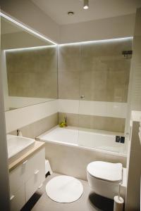 ein Badezimmer mit einem WC, einer Badewanne und einem Waschbecken in der Unterkunft ULMA apartment in Wieliczka