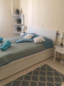 een slaapkamer met een bed met kussens erop bij Modern Apartment in Pafos Near the Sea in Paphos City
