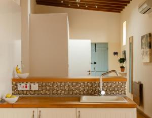a kitchen with a sink and a mirror at Dolphin Guest House and Studios in Tochni