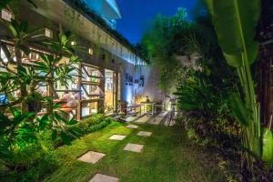 a courtyard of a building with plants in the yard at Lokal Bali Hostel in Kuta