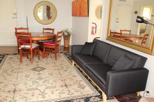 a living room with a black couch and a table at Brandis Beach House in Guilderton