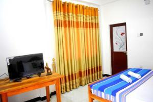 a room with a tv and a bed and a table at Herbage Natural Ella in Ella