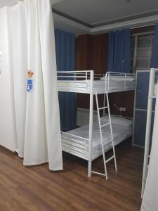 a small room with a bed and a door at Albergue Turístico La Peregrina in Oviedo
