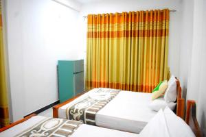 a bedroom with two beds and a curtain at Herbage Natural Ella in Ella