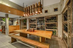 a dining room with a wooden table and benches at Lokal Bali Hostel in Kuta