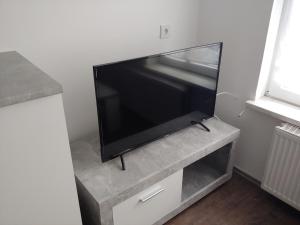 een flatscreen-tv op een stand in een kamer bij Bei Dinos in Sarstedt