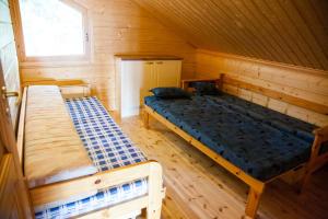 a room with two beds in a wooden cabin at Kotoranta in Kouvola