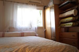1 dormitorio con cama y ventana en Goldy Suite, en Haifa