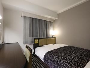 a bedroom with a bed and a window at APA Hotel Kanda Jimbocho Ekihigashi in Tokyo