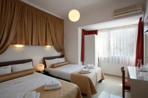 a hotel room with two beds and a window at Metropolis Hotel in Athens