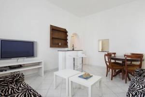 ein Wohnzimmer mit einem Sofa und einem TV in der Unterkunft Roma Ostia 100 mt sea in Lido di Ostia