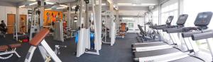 ein Fitnessstudio mit Reihen von Laufbändern und Geräten in der Unterkunft Good Room in Uttaradit