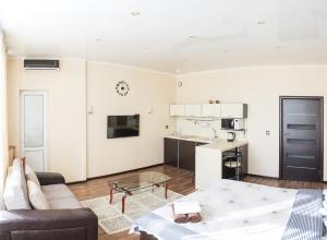 a living room with a couch and a kitchen at Apartment on Kunayeva 38 in Shymkent
