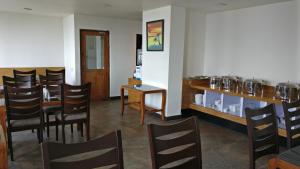 a dining room with a bunch of chairs and a counter at Hotel Ninamma in Gangtok