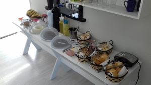 una mesa blanca con varias cestas de comida. en Pousada Guanumbi en Morretes