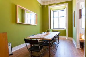 a dining room with green walls and a wooden table and chairs at Sao Pedro de Alcantara 63 by Central Hill Apartments in Lisbon