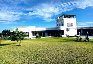 a white building with a grass field in front of it at Really good home in Taitung City