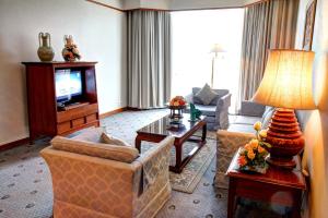 a living room with a couch and a television at The Empress Hotel - SHA Extra Plus in Chiang Mai