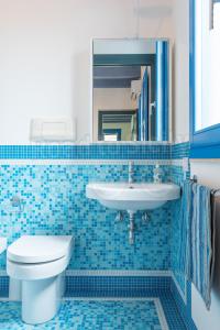een blauw betegelde badkamer met een toilet en een wastafel bij Casa Azzurra - Road to Sicily in Marina di Ragusa