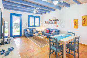 een woonkamer met een blauwe bank en een tafel bij Casa Azzurra - Road to Sicily in Marina di Ragusa