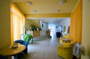 a hallway with chairs and tables in a room at Club MenDan Aparthotel in Zalakaros