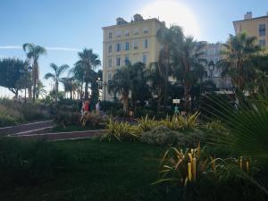 a building with palm trees in front of a park at Perla Duplex - No Better Location In Nice in Nice