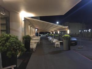 a row of tables and chairs on a patio at night at Hotel Rex in Piriápolis