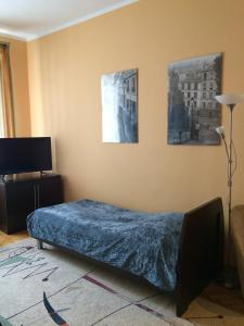 グディニャにあるApartament Centrum Gdyniaのベッドルーム1室(ベッド1台付)が備わります。壁に2枚の写真が飾られています。