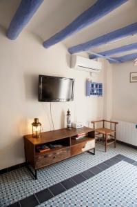 sala de estar con TV de pantalla plana en la pared en El 3 del Holandés, en Balaguer