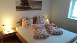 sypialnia z łóżkiem z 4 poduszkami w obiekcie Ferienwohnung Evi w mieście Dalaas