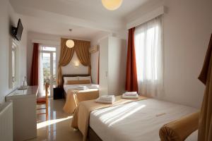 a hotel room with two beds and a window at Metropolis Hotel in Athens