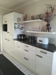 a kitchen with white cabinets and a black counter top at BS Business Travelling in Hannover