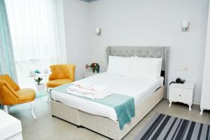 1 dormitorio blanco con 1 cama y 1 silla en Nar Palace, en Estambul