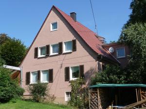 una casa rosa con techo rojo en Grüne Oase, en Hargesheim